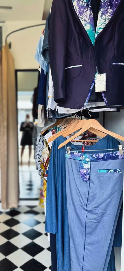 Vestiaire bleu Wax.by.Mona présenté sur un portant en boutique