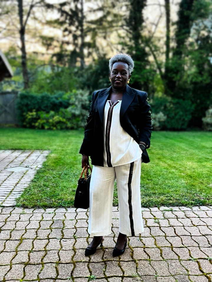 Femme portant un ensemble ivoire à galon noir avec une veste noire Wax.by.Mona